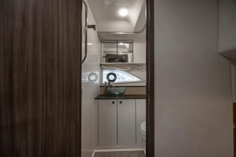 Slide: The Image of 2020 Sea Ray Sundancer 320 Outboard interior bathroom with modern fixtures and wood accents. - 55