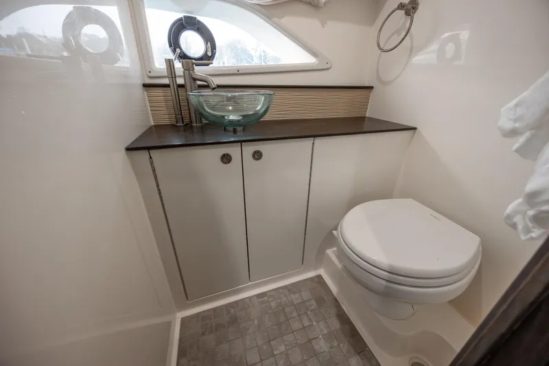 Slide: The Image of 2020 Sea Ray Sundancer 320 Outboard bathroom with modern sink and toilet. - 56