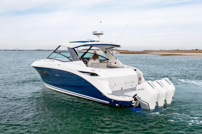 Slide: The Image of 2020 Sea Ray Sundancer 320 Outboard cruising on open water, showcasing sleek design and powerful engines. - 6