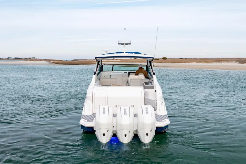Slide: The Image of 2020 Sea Ray Sundancer 320 Outboard cruising in calm waters near a sandy shoreline. - 7