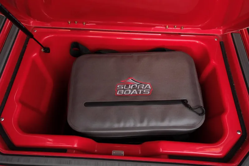 Slide: The Image of 2025 Supra SE boat storage compartment with Supra Boats branded bag. - 23