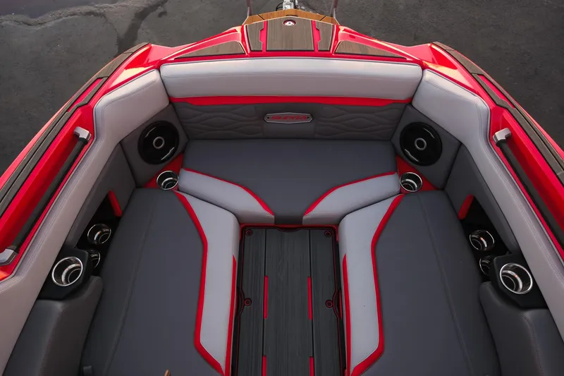 Slide: The Image of 2025 Supra SE boat interior with red and gray seating, speakers, and cup holders. - 24