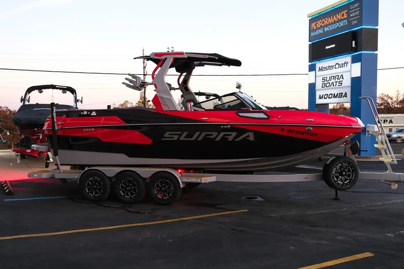 Slide: The Image of 2025 Supra SE boat on trailer at dealership, showcasing sleek design and vibrant colors. - 7