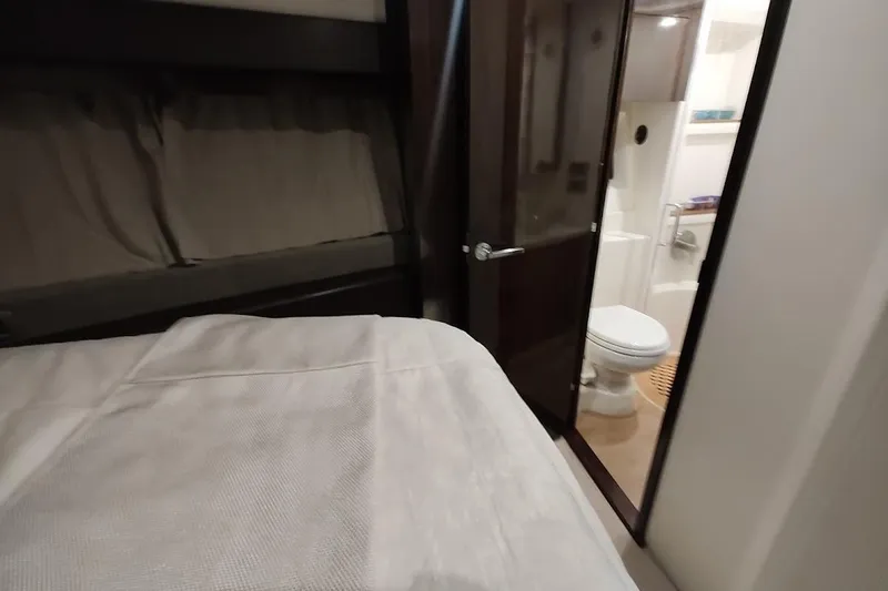 Slide: The Image of 2017 Sea Ray Sundancer 400 cabin interior with bed and bathroom view. - 23