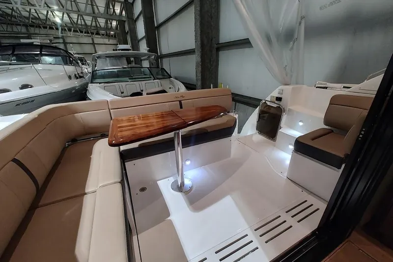 Slide: The Image of 2017 Sea Ray Sundancer 400 interior with seating and wooden table in a marina setting. - 8