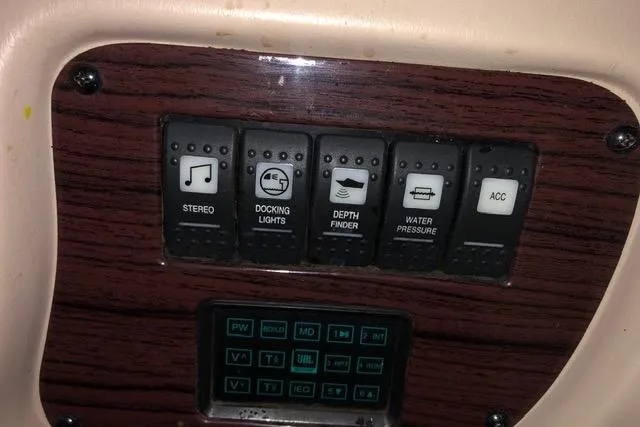 Slide: The Image of Control panel of a 2003 Chaparral Signature 260 boat with various switches. - 19