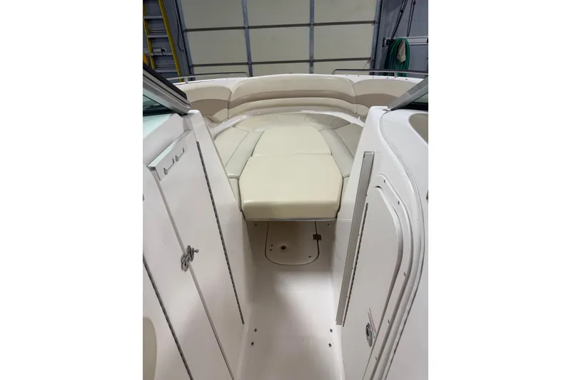 Slide: The Image of 2003 Chaparral Signature 260 boat interior with beige seating and storage compartments. - 6
