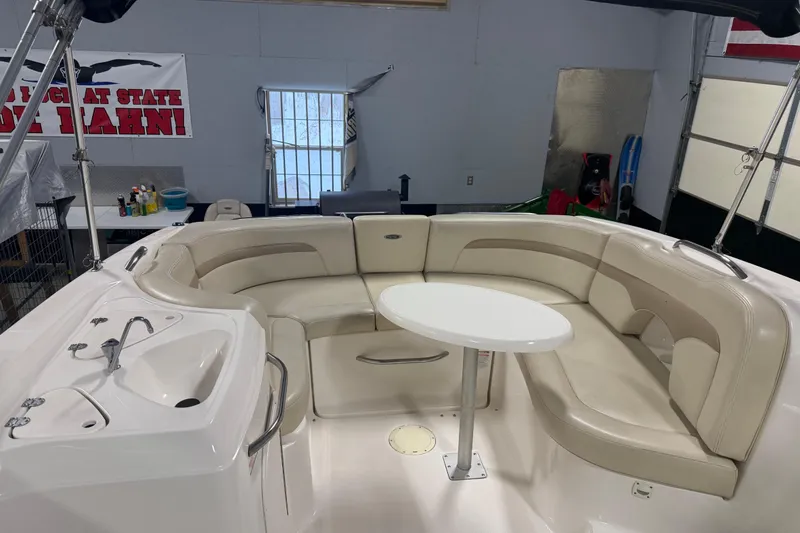 Slide: The Image of 2003 Chaparral Signature 260 boat interior with beige seating and a round table. - 9