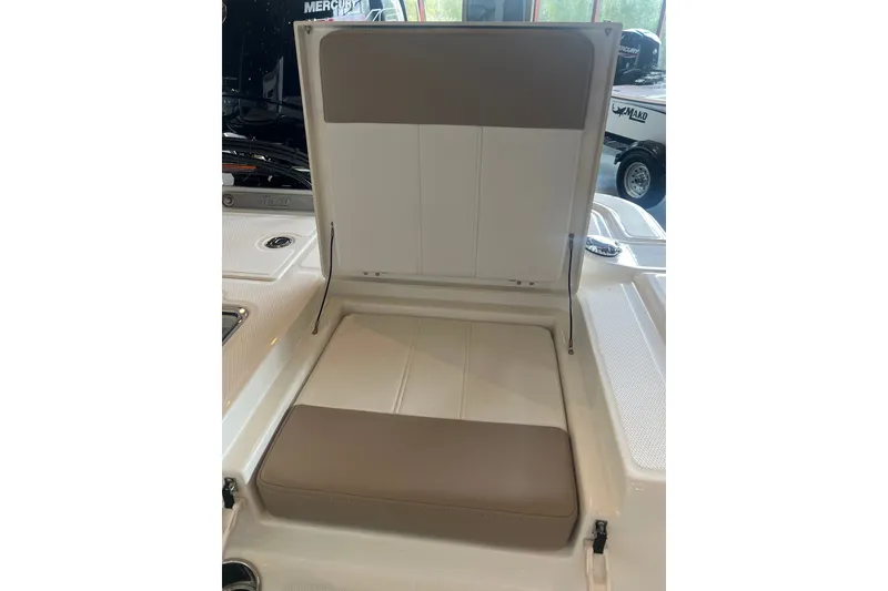 Slide: The Image of 2026 Mako Pro Skiff 19 CC boat seat with storage compartment open. - 11