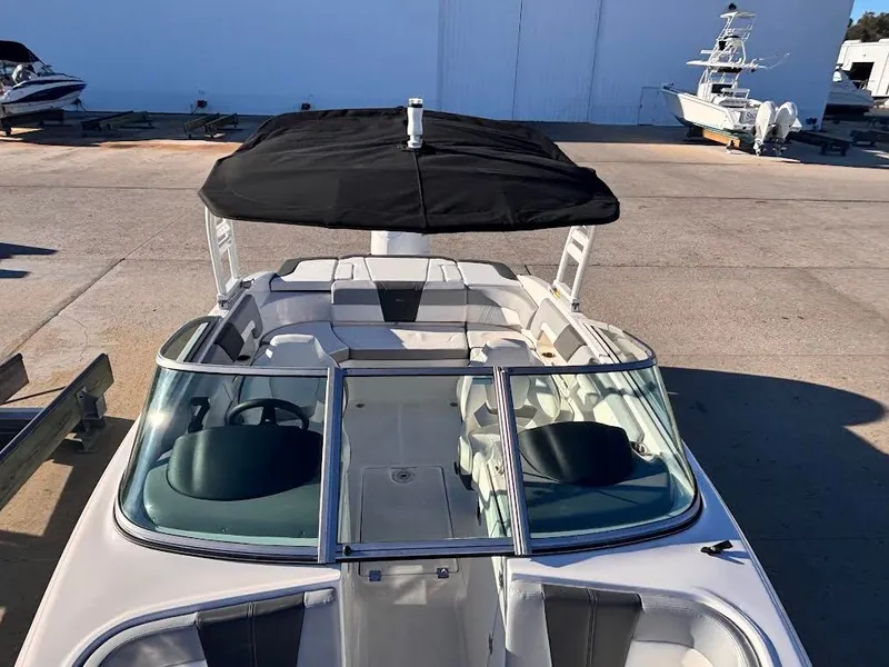 Slide: The Image of 2022 Chaparral 23 SSi OB boat with black canopy in harbor. - 13