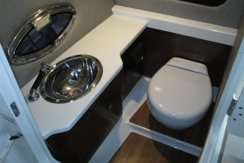 Slide: The Image of 2018 Chaparral 287 SSX boat bathroom with sink and toilet, featuring modern design. - 13