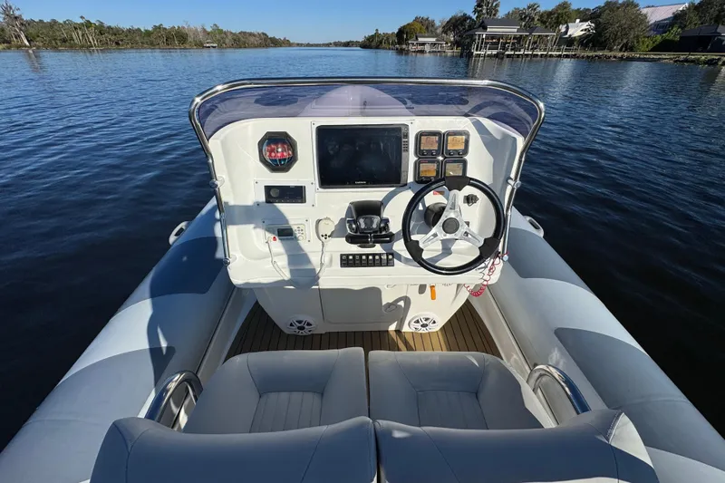 Slide: The Image of Cockpit view of 2010 Cobra Ribs Nautique 8.6m boat on a serene river. - 10