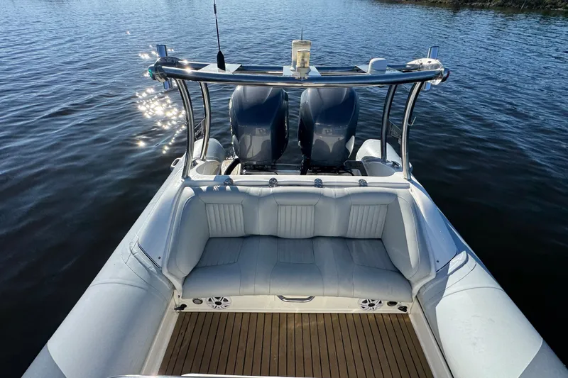 Slide: The Image of 2010 Cobra Ribs Nautique 8.6m boat with twin engines and cushioned seating on water. - 14