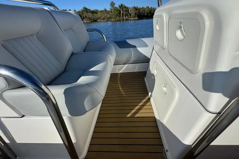 Slide: The Image of Interior of 2010 Cobra Ribs Nautique 8.6m boat with white seating and wooden deck. - 16