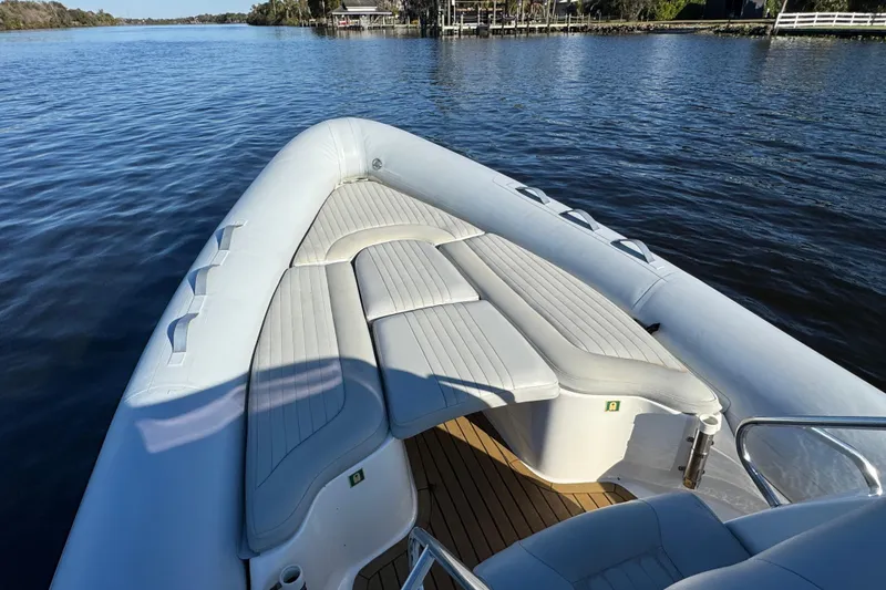 Slide: The Image of 2010 Cobra Ribs Nautique 8.6m boat with cushioned seating on calm water. - 17