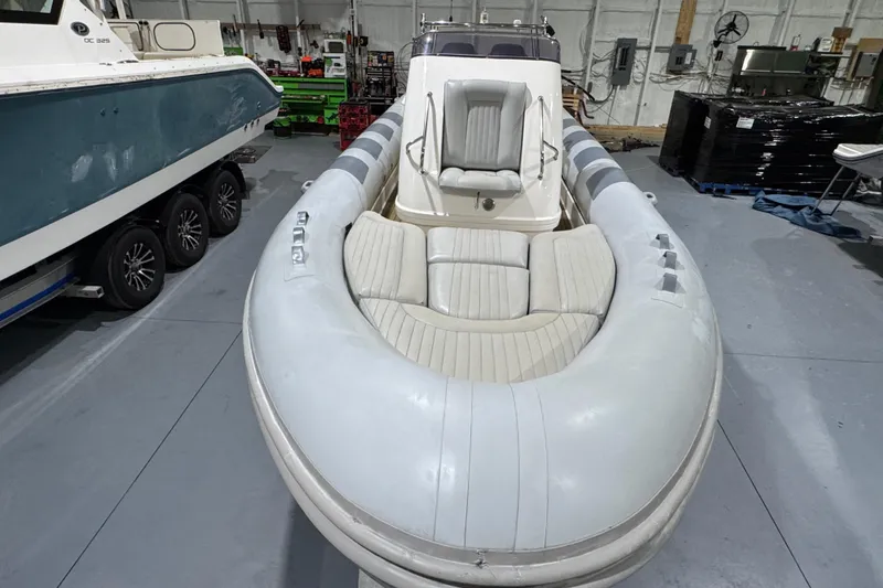 Slide: The Image of 2010 Cobra Ribs Nautique 8.6m inflatable boat with white seating in a storage facility. - 18