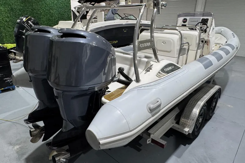 Slide: The Image of 2010 Cobra Ribs Nautique 8.6m boat with dual outboard motors on a trailer. - 8