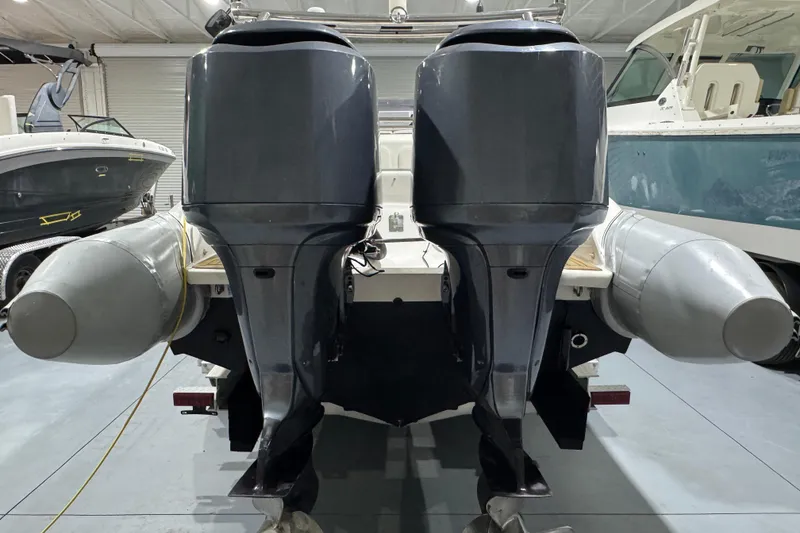Slide: The Image of 2010 Cobra Ribs Nautique 8.6m with dual outboard motors in a boat storage facility. - 9