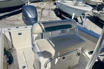 Slide: The Image of 2019 Cobia 237 Center Console boat with seating and outboard motor in a marina setting. - 11