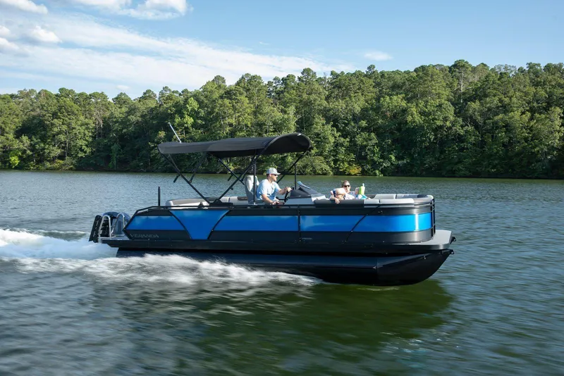 The Image of 2026 Veranda VR235L pontoon boat cruising on a scenic lake. - 2