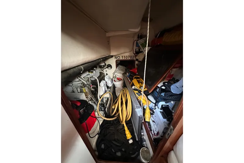 Slide: The Image of Storage compartment in a 2000 Outbound 44 boat, filled with cables and equipment. - 59