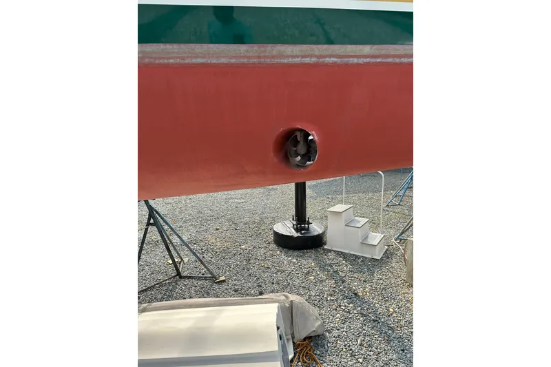 Slide: The Image of Red hull of 2000 Outbound 44 sailboat with visible propeller, supported on stands. - 65