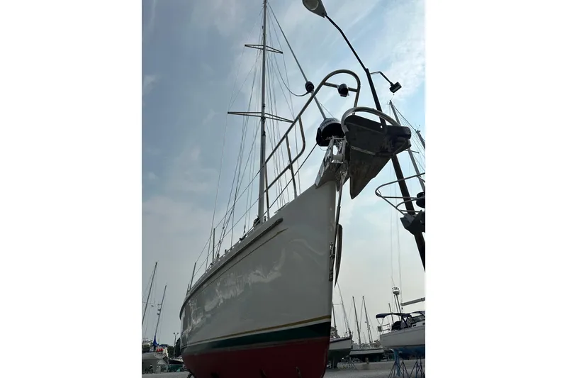 Slide: The Image of Sailboat Outbound 44, 2000 model, docked with masts against a cloudy sky. - 74