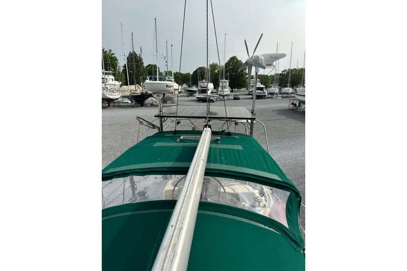 Slide: The Image of Sailboat Outbound 44, 2000 model, docked with green cover and solar panels. - 75