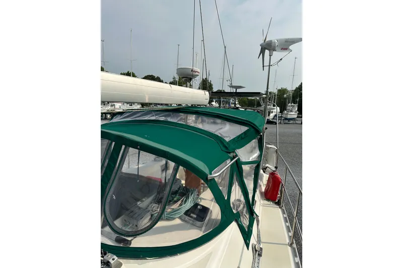 Slide: The Image of Sailboat with green canopy, Outbound 44 model, year 2000, docked in marina. - 79