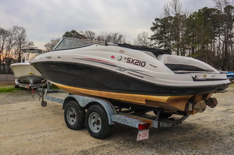 Slide: The Image of 2006 Yamaha Boats SX210 on trailer, parked outdoors, showcasing twin engine design. - 4