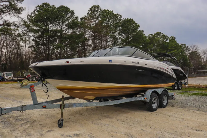 Slide: The Image of 2006 Yamaha Boats SX210 on trailer, parked outdoors with trees in background. - 6