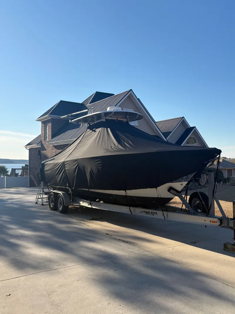 Slide: The Image of 2016 Sea Hunt Gamefish 27 boat on trailer in front of house. - 28