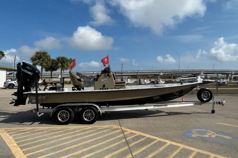 Slide: The Image of 2026 Skuta 24 Vista boat on trailer, parked outdoors under a clear blue sky. - 2