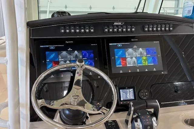 Slide: The Image of Control panel of a 2020 Boston Whaler 330 Outrage with dual navigation screens and steering wheel. - 19