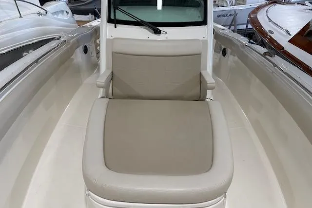 Slide: The Image of 2020 Boston Whaler 330 Outrage boat interior with cushioned seating area. - 20