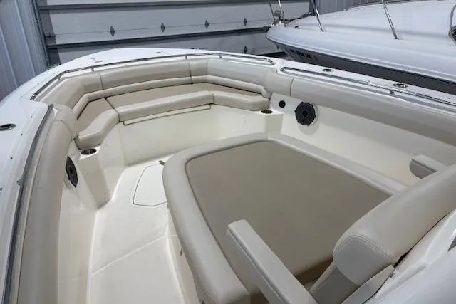 Slide: The Image of 2020 Boston Whaler 330 Outrage boat interior with cushioned seating and sleek design. - 21