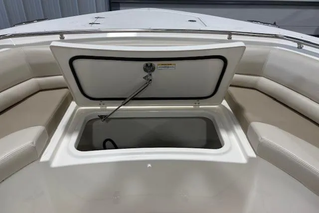 Slide: The Image of 2020 Boston Whaler 330 Outrage boat with open storage compartment and cushioned seating. - 22