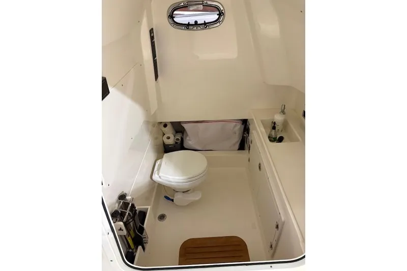 Slide: The Image of 2020 Boston Whaler 330 Outrage cabin interior with toilet and sink. - 24