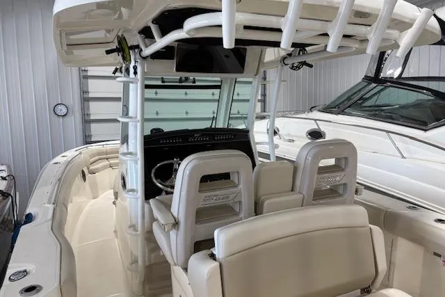 Slide: The Image of 2020 Boston Whaler 330 Outrage boat interior with helm and seating in a storage facility. - 32
