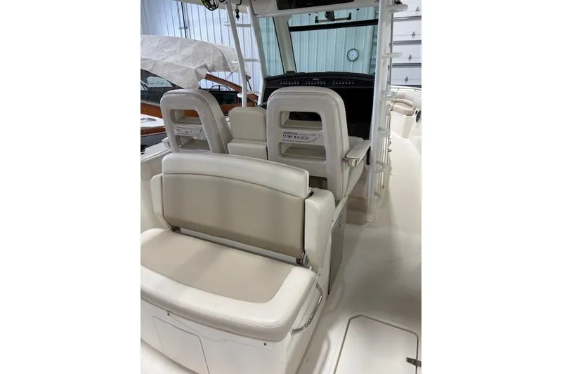 Slide: The Image of 2020 Boston Whaler 330 Outrage interior with beige seating and helm station. - 35