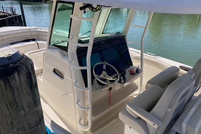 Slide: The Image of 2020 Boston Whaler 330 Outrage boat cockpit with steering wheel and navigation system. - 4