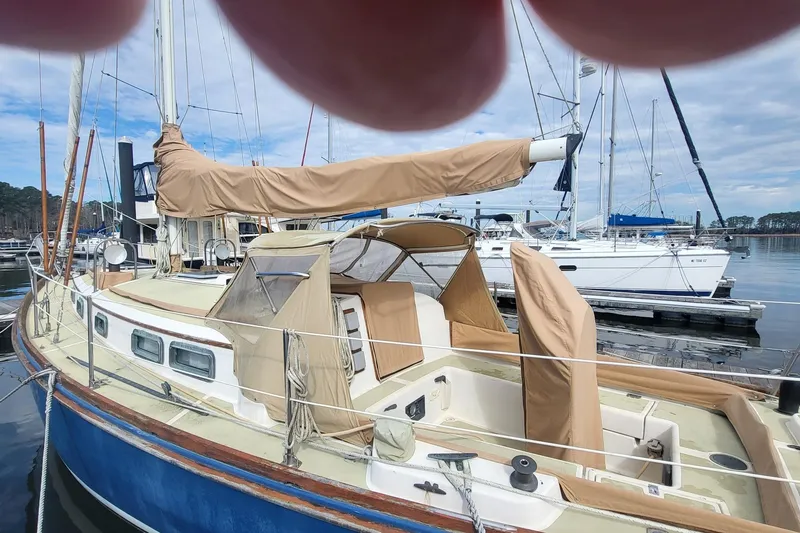 Slide: The Image of 1984 Sea Sprite 34 sailboat docked at marina, covered in beige canvas. - 13