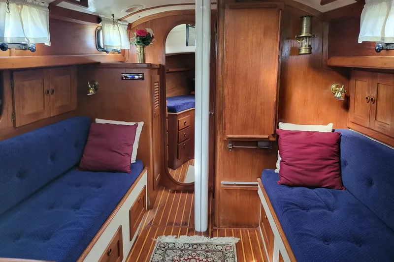 Slide: The Image of Cozy 1984 Sea Sprite 34 yacht interior with blue seating, wooden cabinetry, and decorative pillows. - 18