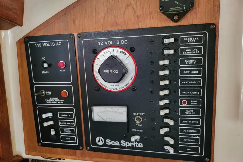 Slide: The Image of Electrical control panel of a 1984 Sea Sprite 34 boat, featuring AC and DC switches. - 25
