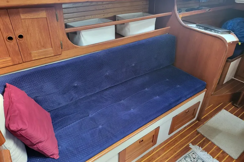 Slide: The Image of Interior of 1984 Sea Sprite 34 sailboat with blue cushioned seating and wooden cabinetry. - 28