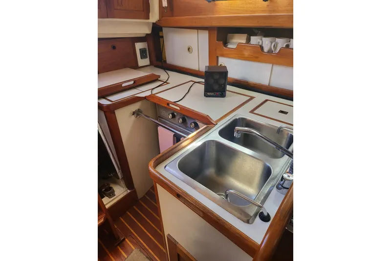Slide: The Image of 1984 Sea Sprite 34 yacht kitchen with dual sinks and wooden cabinetry. - 5