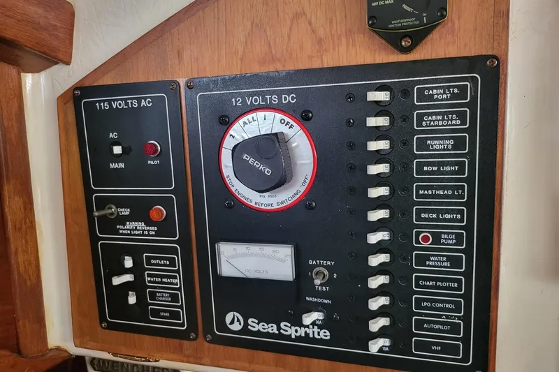 Slide: The Image of Electrical control panel of a 1984 Sea Sprite 34 boat, featuring AC and DC switches. - 8