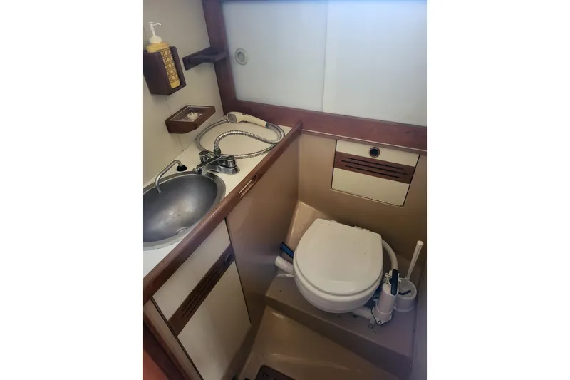 Slide: The Image of 1984 Sea Sprite 34 yacht bathroom with sink, toilet, and wooden accents. - 9