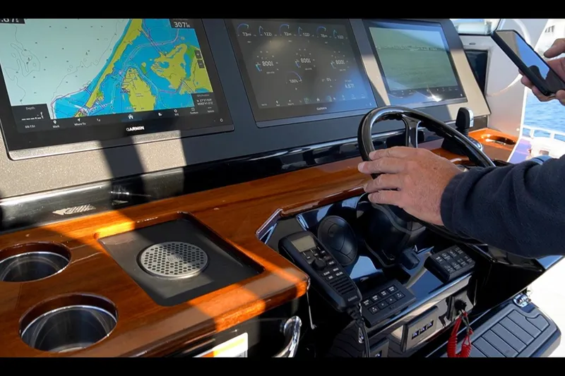 Slide: The Image of 2024 Everglades 395 Center Console dashboard with navigation screens and steering wheel. - 11