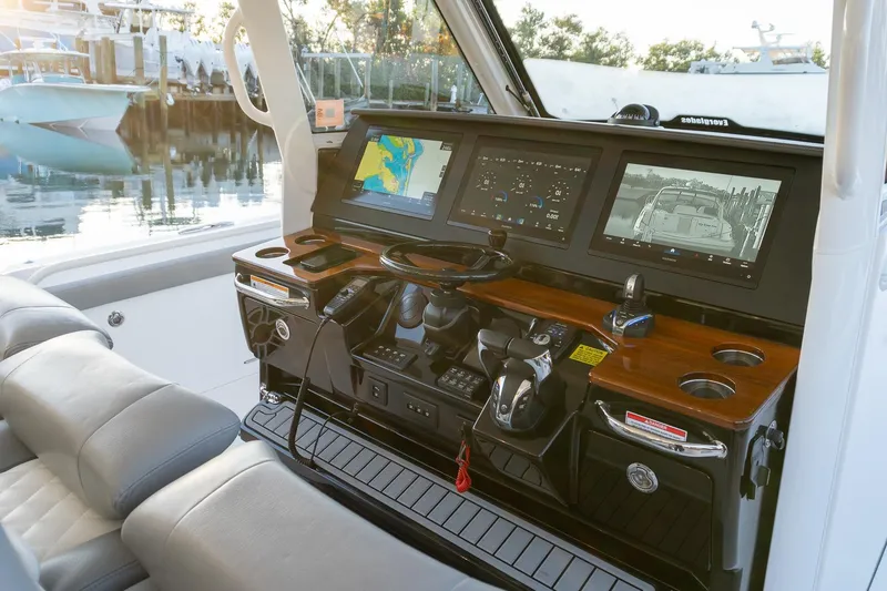 Slide: The Image of 2024 Everglades 395 Center Console helm with advanced navigation displays and controls. - 12